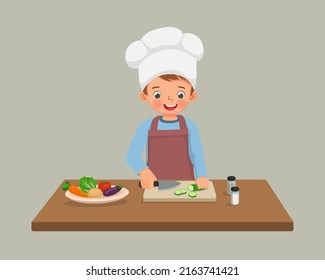 cute little girl chef cooking meal cutting slicing cucumber vegetable with knife in the kitchen