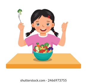 Cute little girl eating vegetables fruits salad showing thumb up