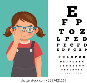 Cute little girl with eyeglasses cover her eye having vision test reading block letters at ophthalmologist office