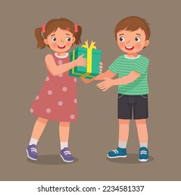 cute little girl giving gift to a boy for his birthday or Christmas present 