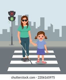 Cute little girl helping blind woman crossing street at the pedestrian traffic