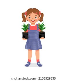 cute little girl holding Seedlings of plants in black plastic bags ready for planting in the garden