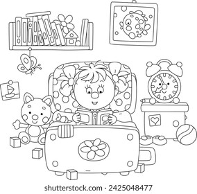 Cute little girl lying in her pretty small bed and reading an interesting book with fairy tales among funny toys in a nursery room, black and white vector cartoon illustration for a coloring book