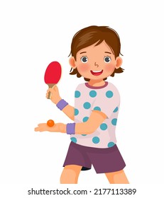 Cute little girl playing table tennis in serving position ready to strike the ping pong ball with paddle