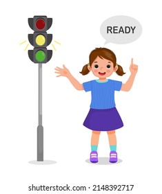 cute little girl pointing and showing traffic light indicator yellow light on