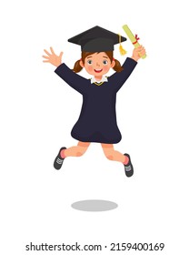 cute little girl student in graduation gown holding certificate diploma jumping in happy graduation day