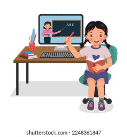 Cute little girl studying from home via Internet video conference with teacher using computer desktop