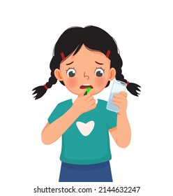 cute little girl taking medicine capsule with a glass of water