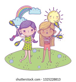 cute little girls playing maracas in the landscape