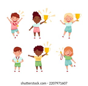 Cute little kids athletes holding trophy cups and medals set. Happy boys and girls celebrating win cartoon vector illustration