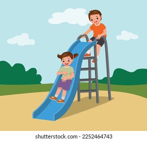 Cute little kids boy and girl having fun on slide in playground at the park