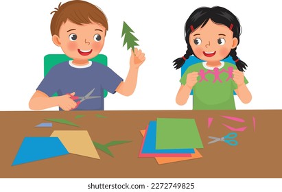 Cute little kids boy and girl cutting colored paper with scissors making paper cut art craft