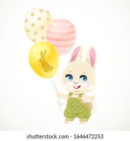 Cute little rabbit in a green jumpsuit with polka dots holding balloons in the paws isolated on white background