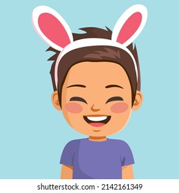 Cute little smiling boy wearing bunny ears celebrating Easter holiday