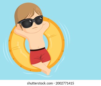 Cute little toddler boy wearing sunglasses making cool pose on inflatable ring at swimming pool