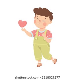 Cute loving little boy with pink heart. Brown haired boy dressed jumpsuit giving kiss cartoon vector illustration