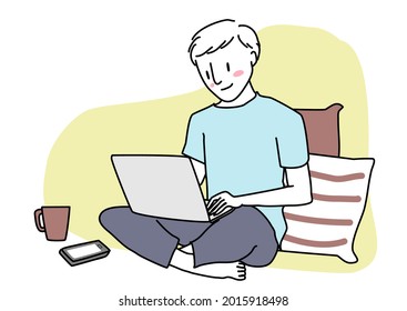 Cute man sitting comfortably on the floor and using laptop computer. Happy young man using computer at living room. Cheerful man with laptop computer sitting on a floor. Man working from home.