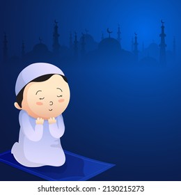Cute Muslim Boy Praying (Namaz) And Copy Space On Blue Silhouette Mosque Background For Islamic Festival Concept.