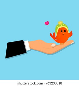Cute orange bird sitting on a male hand. Cute bird toy or animal presenting