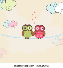 Cute owl couple in love holding hands together on colorful clouds background for Happy Valentine's Day celebrations.