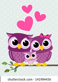 cute owls couple with baby owl sitting on a branch