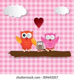 cute owls couple with baby owl sitting on a branch