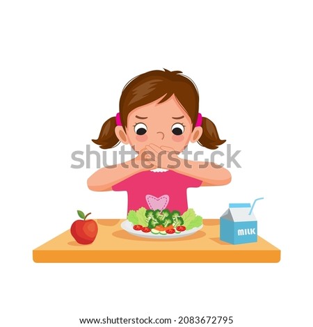 Cute picky eater little girl unhappy covering her mouth refusing to eat fruits and vegetables.