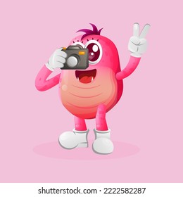 Cute pink monster taking photo with camera. Perfect for kids, small business or e-Commerce, merchandise and sticker, banner promotion, blog or vlog channel
