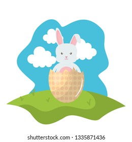 cute rabbit with broken easter egg painted in the field