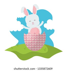 cute rabbit with broken easter egg painted in the field