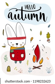Cute rabbit is in fashionable clothes and is heated by the fire. Fall, autumn illustration. Vector