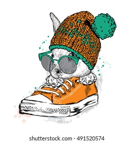 Cute rabbit with glasses and a hat with a bubo. Hare sitting in sneakers. Vector illustration for greeting card, poster, or print on clothes. Fashion & Style.