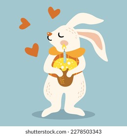 cute rabbit holds in its paws an Easter cake with candles