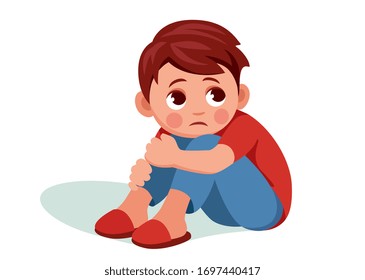 Cute sad boy sitting at home on floor with his head on his knees. Upset because he was bored or offended