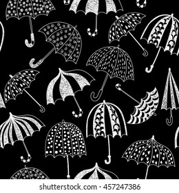 Cute seamless pattern with doodle umbrellas on a black background. Vector illustration.