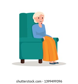 Cute smiling pensioner woman stay in green soft armchair