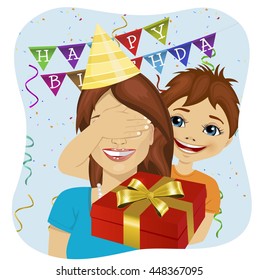 cute son covering her mother eyes giving surprise gift at birthday anniversary party