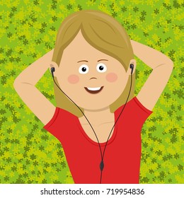 Cute teenager girl listening to music with headset using smartphone lying on grass