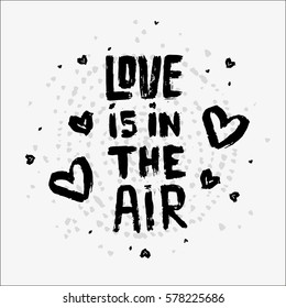 Cute text made of dry brush and ink. Worn brushes ragged texture and circular watercolor dots pattern on the background. Little hearts in a chaotic manner. Text saying Love is in the air