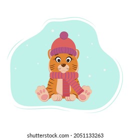 cute tiger is sitting in a hat and scarf and snowing