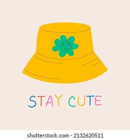 Cute vector illustration with yellow panama hat and green daisy flower with funny face. Handwritten lettering quote stay cute. 