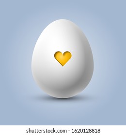 Cute white egg with a yellow heart in the shell, easter or valentine's egg, concept of newborn and pregnancy