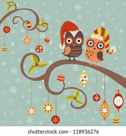 Cute winter Christmas card of owls in hats sitting on a tree branch with ball toys