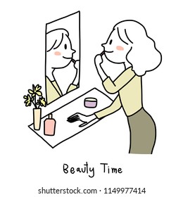 Cute woman looking at her reflection in a mirror and apply lipstick. Young woman touching up her makeup in dressing room. Woman with long hair putting on lip gloss in front of a mirror in powder room.