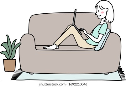 Cute woman sitting with knees up on couch and using laptop. Work From Home concept with young woman using computer on sofa. Woman lying comfortably on couch, typing on laptop keyboard at home.