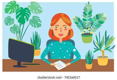 Cute women sitting at the table in the green fresh full of plants office and working on the computer.