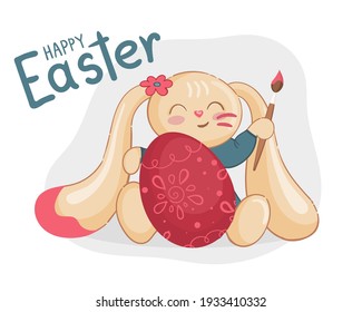 Cute yellow rabbit with a brush in his hand paints a red Easter egg. The inscription "Happy Easter".
Cartoon character in vector illustration.