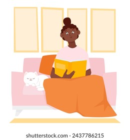 Cute young black woman sitting on the sofa and reading a book