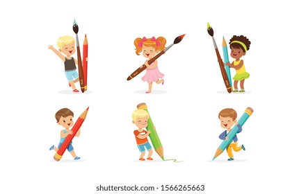 Cute Young Children Holding Big Pencils and Pens