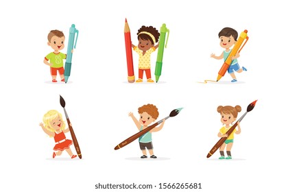 Cute Young Children Holding Big Pencils and Pens